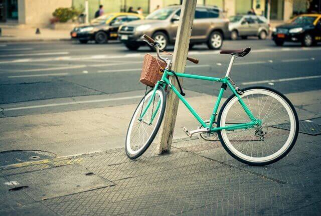 Bicicleta presa em um poste na cidade.