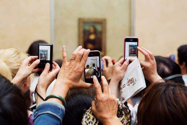 pessoas fotografando o quadro da monalisa