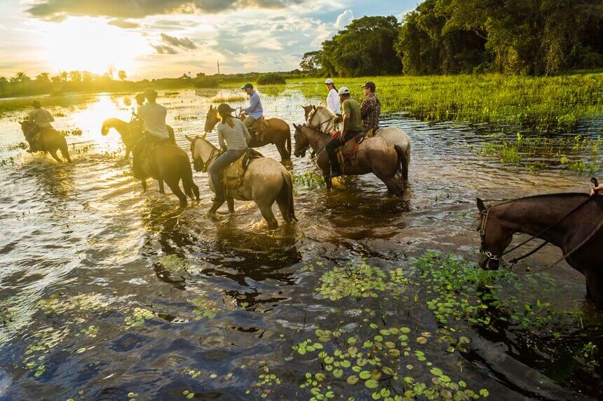 pessoas andando á cavalo