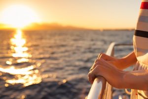 Closeup of female hands on a yacht during sunset.