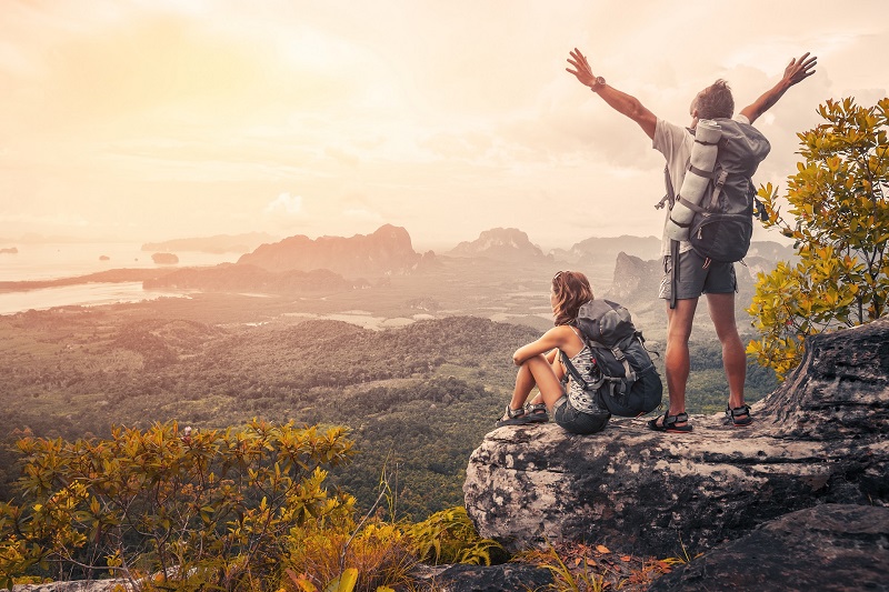 A imagem mostra um casal fazendo trekking